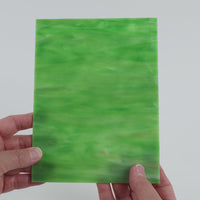 Video of the Green White glass plate in ripple translucent green, 15x19cm, held up and tilted to show its pattern and transparency
