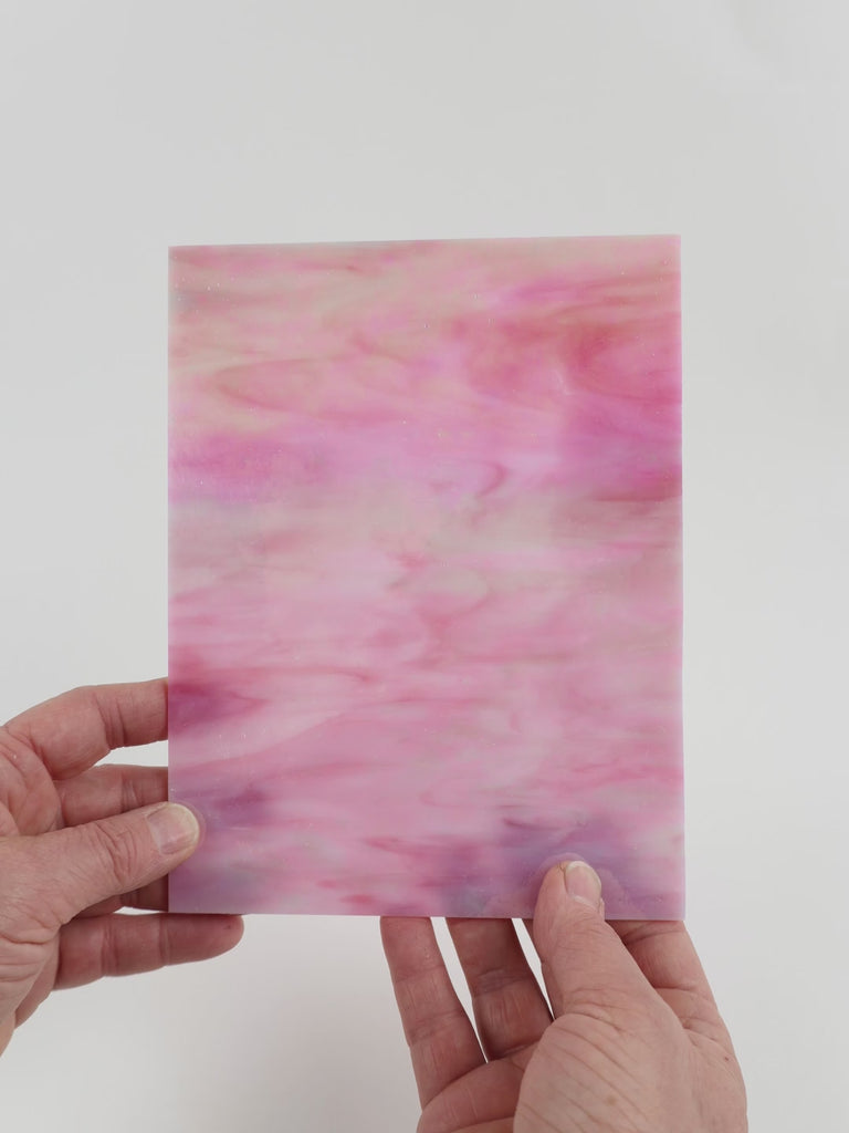 Video of the Pink iridescent glass plate in iridescent translucent pink, 15x19cm, held up and tilted to show its pattern and transparency