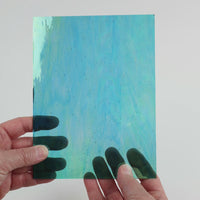 Video of the Teal iridised glass plate in iridescent transparent teal, 15x19cm, held up and tilted to show its pattern and transparency
