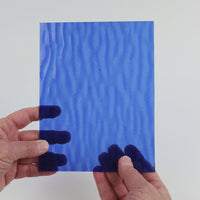 Video of the Blue Gentle Waves glass plate in ripple transparent blue, 15x19cm, held up and tilted to show its pattern and transparency