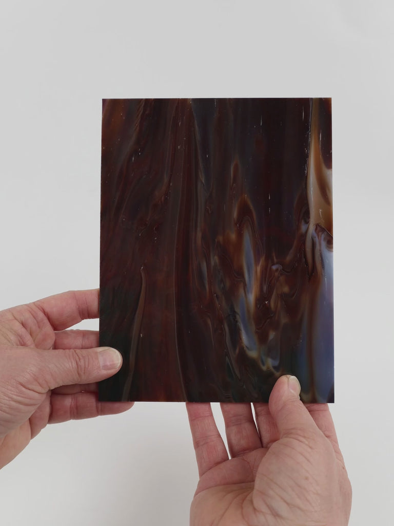 Video of the Oak glass plate in opaque brown, 15x19cm, held up and tilted to show its pattern and transparency