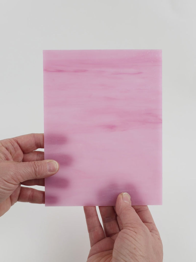 Video of the Pink Streaky glass plate in translucent pink, 15x19cm, held up and tilted to show its pattern and transparency