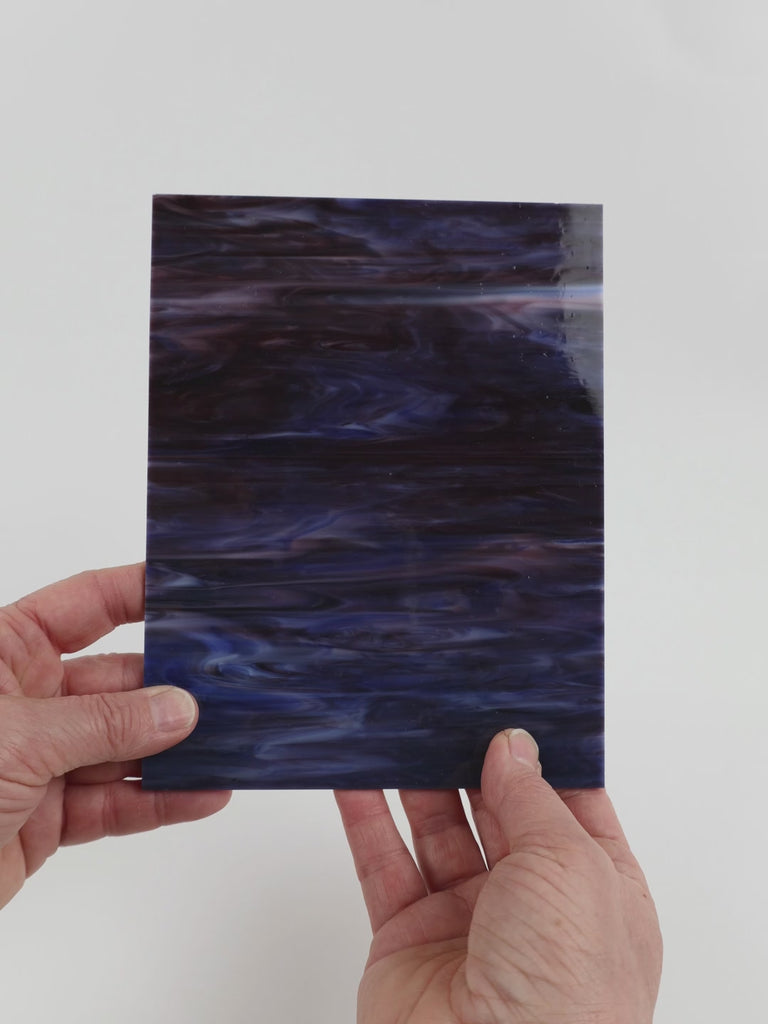 Video of the Northern Lights glass plate in translucent blue, 15x19cm, held up and tilted to show its pattern and transparency