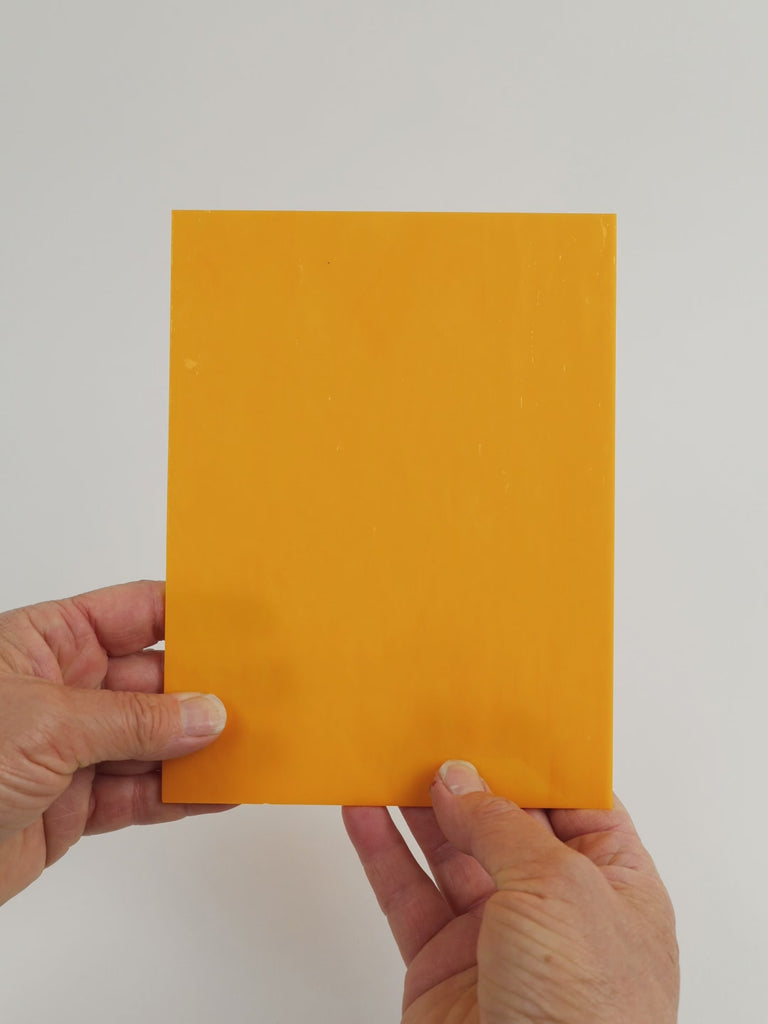 Video of the Mango Nectar glass plate in opaque orange, 15x19cm, held up and tilted to show its pattern and transparency