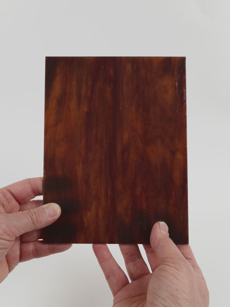 Video of the Mahogany glass plate in translucent brown, 15x19cm, held up and tilted to show its pattern and transparency