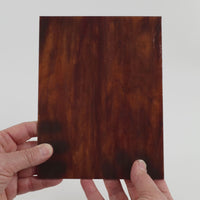 Video of the Mahogany glass plate in translucent brown, 15x19cm, held up and tilted to show its pattern and transparency