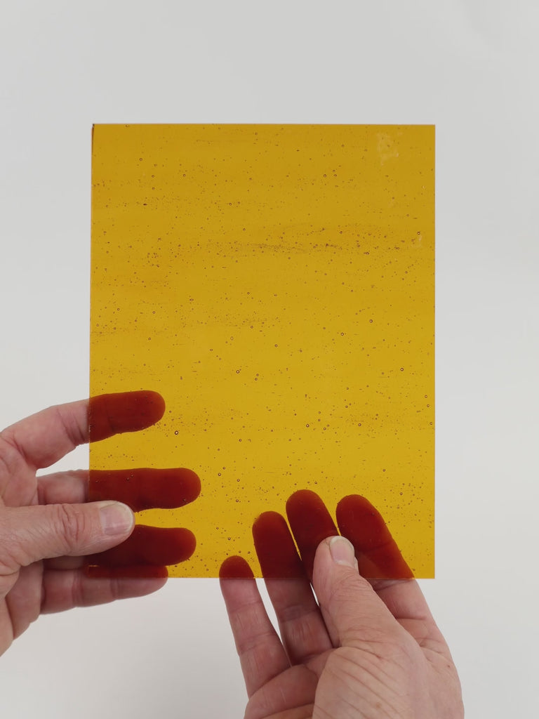 Video of the Golde Syrupglass plate in transparant amber, 15x19cm, held up and tilted to show its pattern and transparency