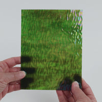 Video of the Camouflage Wavy iridescent glass plate in iridised ripple translucent green, 15x19cm, held up and tilted to show its pattern and transparency