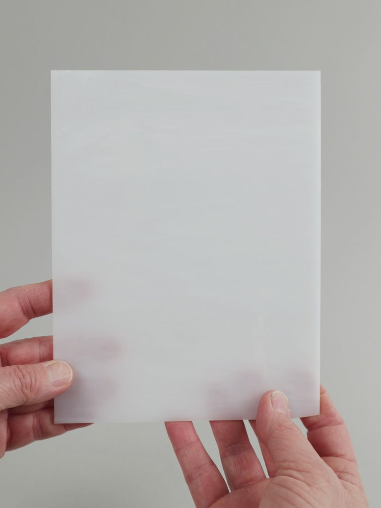Video of the broken white glass plate in white translucent, 15x19cm, held up and tilted to show its pattern and transparency