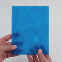 Video of the Deep Turquoise Streaky glass plate in translucent turquoise, 15x19cm, held up and tilted to show its pattern and transparency