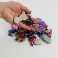 Video of Flip XL ceramic puzzle pieces in rainbow colors, opaque glazed porcelain, 20–60 mm, picked up from a pile by hand and dropped back to show their size, shapes and finish