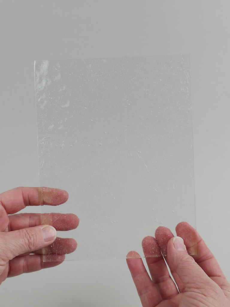 Video of the clear seedy texture glass plate in white transparant, 15x19cm, held up and tilted to show its pattern and transparency