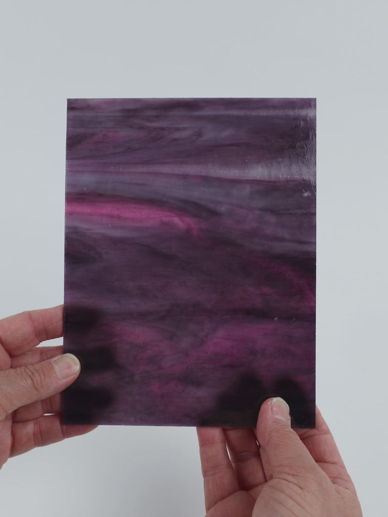 Video of the Violet Magenta Wispy glass plate in translucent purple, 15x19cm, held up and tilted to show its pattern and transparency