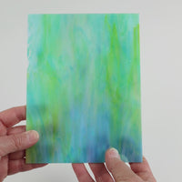 Video of the Teal Marbled Iridised glass plate in iridescent translucent teal, 15x19cm, held up and tilted to show its pattern and transparency