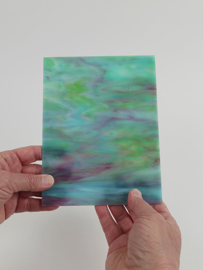 Video of the Turquoise Teal Lilac Ripple glass plate in translucent turquoise, 15x19cm, held up and tilted to show its pattern and transparency