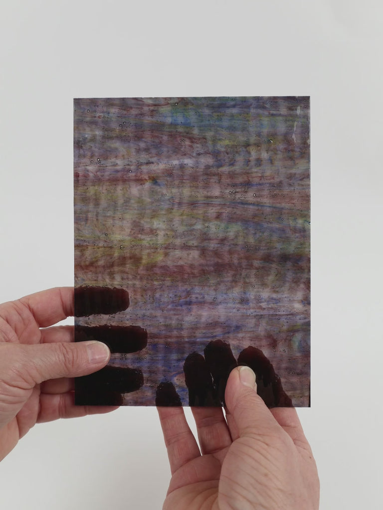 Video of the Walnut Ripple Wispy glass plate in transparant brown, 15x19cm, held up and tilted to show its pattern and transparency