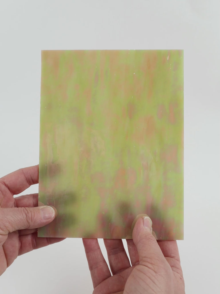 Video of the maple syrup glass plate in brown translucent iridescent, 15x19cm, held up and tilted to show its pattern and transparency