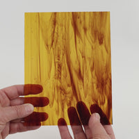Video of the Mid Brown Wispy glass plate in transparant brown, 15x19cm, held up and tilted to show its pattern and transparency