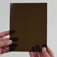Video of the deep khaki glass plate in brown transparant, 15x19cm, held up and tilted to show its pattern and transparency