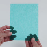 Video of the pale Turquoise Ripple glass plate in ripple transparent turquoise, 15x19cm, held up and tilted to show its pattern and transparency