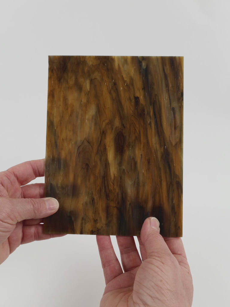 Video of the Deep Brown Marble glass plate in translucent brown, 15x19cm, held up and tilted to show its pattern and transparency