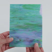 Video of the Soft teal Marbled Iridised glass plate in iridised translucent teal, 15x19cm, held up and tilted to show its pattern and transparency